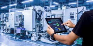 Smart industry control concept.Hands holding tablet on blurred automation machine as background